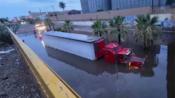 Bomberos rescatan a trailero atrapado en paso a desnivel inundado en Cajeme